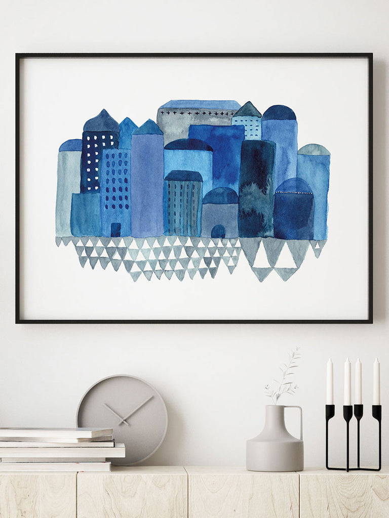 Postern Blues city är ett print av ett original jag målat med flytande tusch. Motivet går i olika blå toner av husfasader med ett torg framför.
